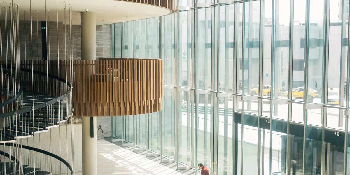 Atrium eines Bürogebäudes mit Wendeltreppe und Glasfassade